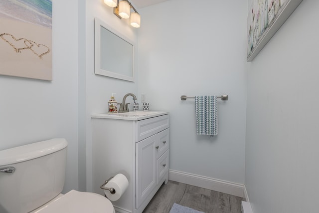 bathroom with hardwood / wood-style floors, toilet, and vanity