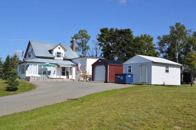 view of front of home featuring a front lawn, an outdoor structure, and a garage