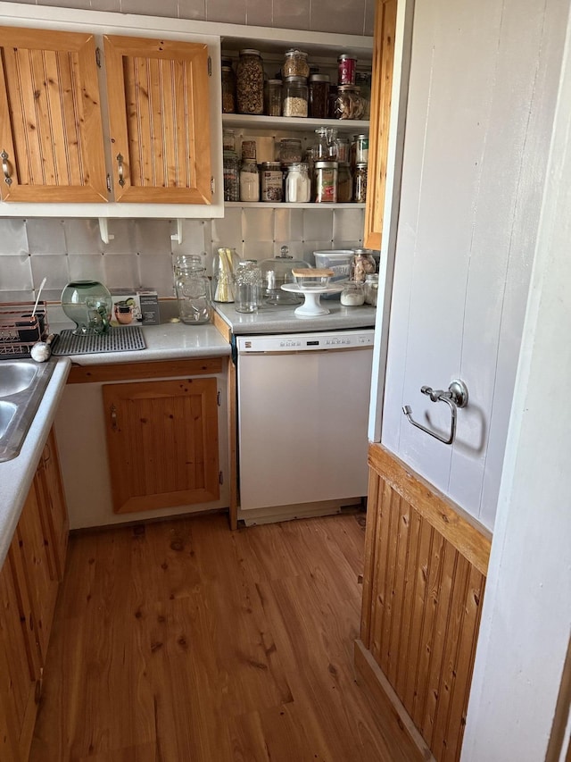 kitchen with white dishwasher, decorative backsplash, and light wood-type flooring