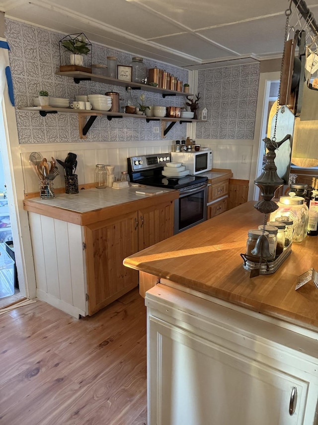 kitchen featuring stainless steel electric stove and light hardwood / wood-style floors