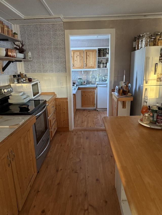 kitchen featuring light hardwood / wood-style floors, backsplash, and white appliances