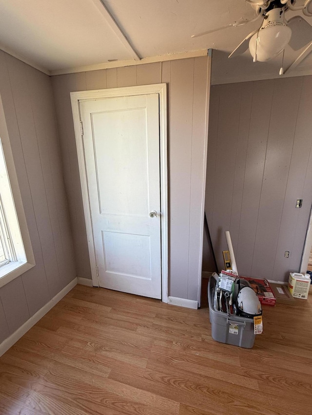 interior space with light wood-style floors, baseboards, and a ceiling fan