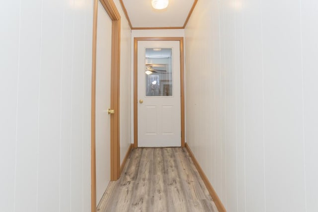 corridor featuring light wood-type flooring and ornamental molding