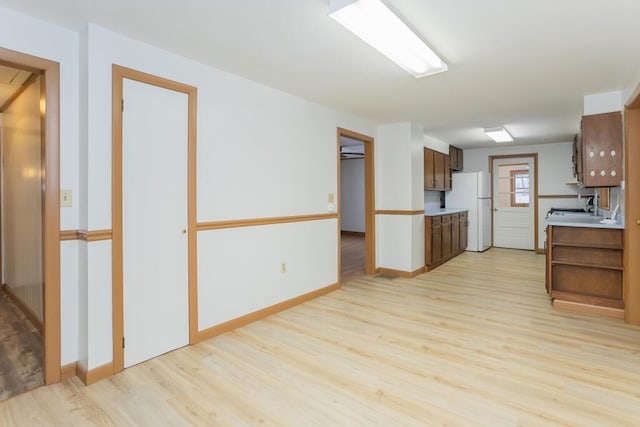 kitchen with light hardwood / wood-style flooring and white fridge