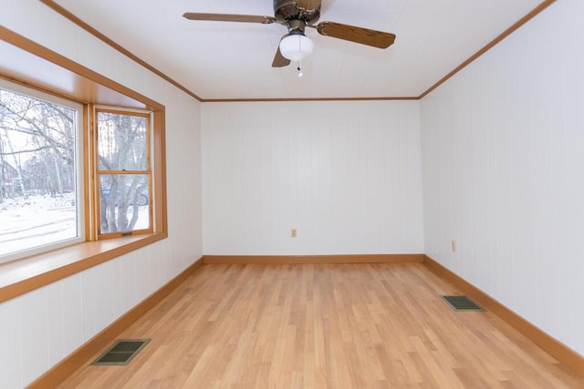 empty room with ceiling fan, ornamental molding, and light hardwood / wood-style flooring