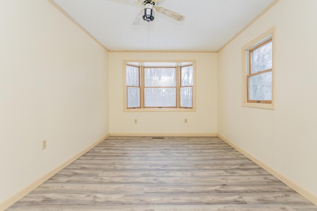 spare room featuring light wood-type flooring, ceiling fan, and ornamental molding