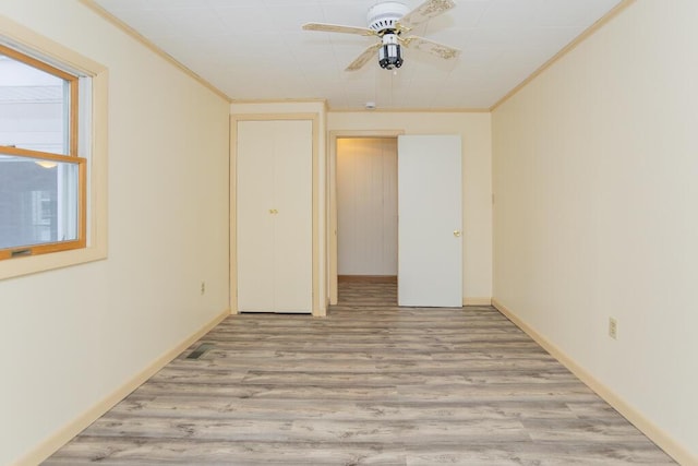 spare room featuring light wood-type flooring, ceiling fan, and ornamental molding