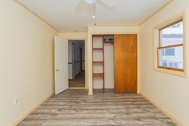 unfurnished bedroom with ceiling fan, hardwood / wood-style floors, and a closet