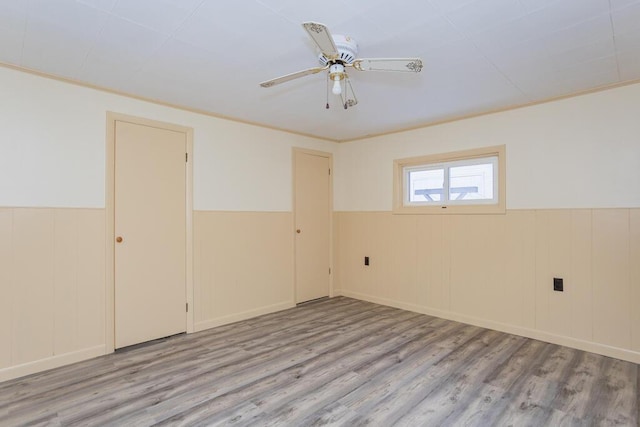 spare room with ornamental molding, light wood-type flooring, and ceiling fan