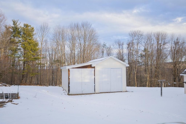 snow covered structure with a garage