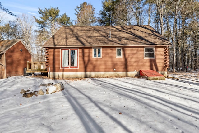 snow covered house featuring a wooden deck