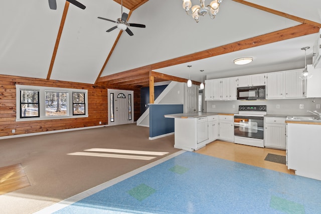 kitchen with white electric stove, wood walls, pendant lighting, white cabinets, and ceiling fan with notable chandelier