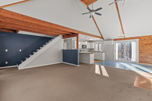 unfurnished living room with ceiling fan, high vaulted ceiling, beamed ceiling, and carpet flooring