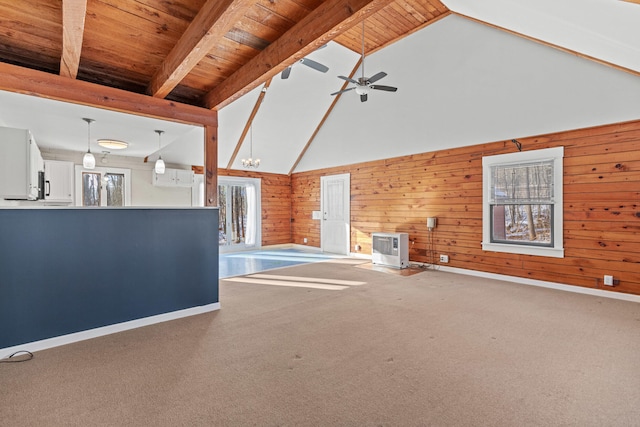 unfurnished living room with wood walls, wood ceiling, high vaulted ceiling, beam ceiling, and ceiling fan with notable chandelier