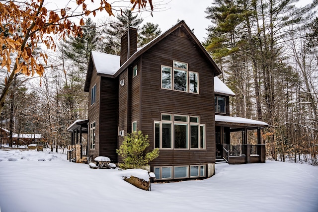 snow covered property featuring covered porch