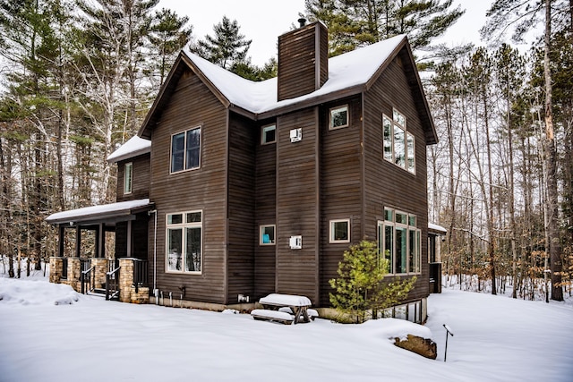 view of snow covered back of property