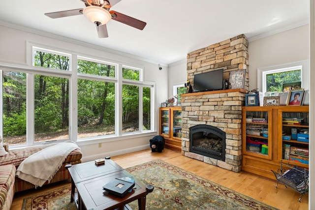 living room with hardwood / wood-style floors, a fireplace, and ornamental molding