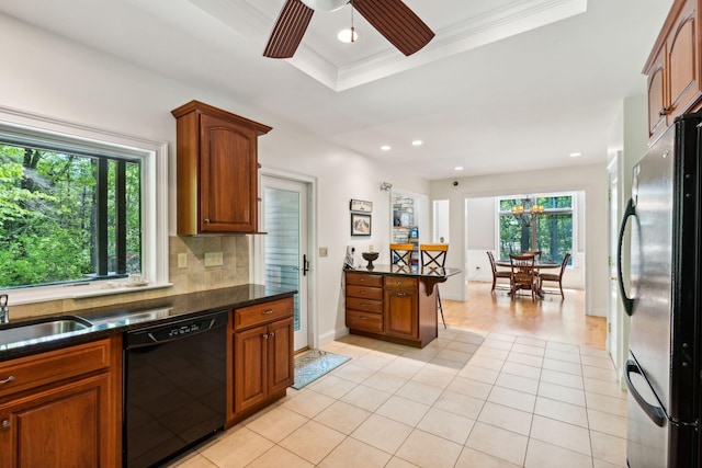 kitchen featuring fridge, dishwasher, ceiling fan, a wealth of natural light, and backsplash