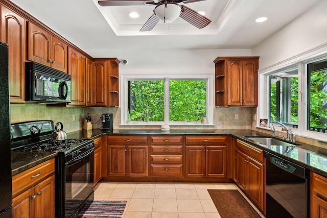 kitchen featuring a raised ceiling, black appliances, light tile patterned floors, ceiling fan, and sink