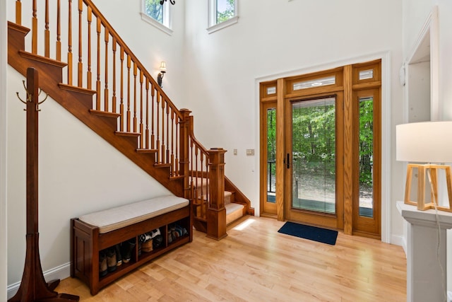 foyer entrance featuring light hardwood / wood-style floors and a high ceiling