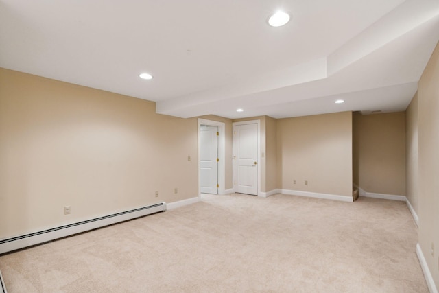 unfurnished room with baseboard heating and light carpet