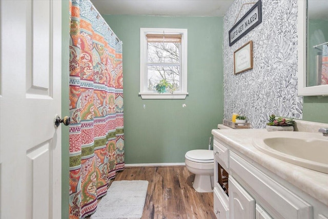 bathroom with toilet, vanity, and hardwood / wood-style flooring