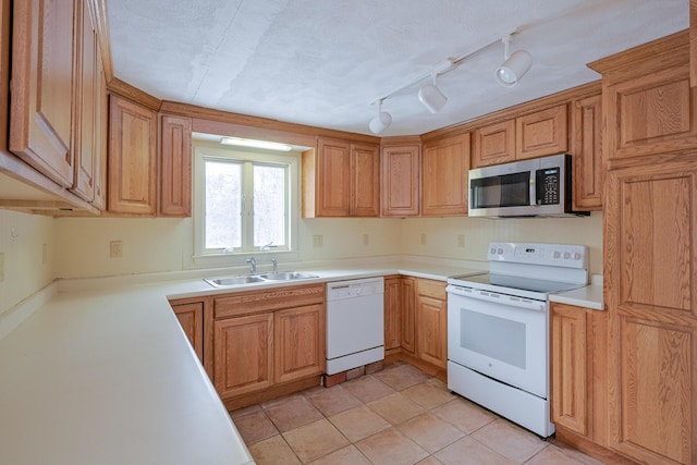 kitchen with white appliances, light tile patterned floors, and sink