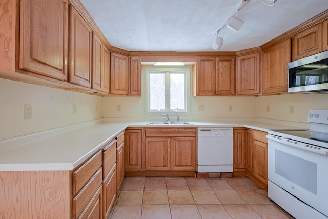 kitchen featuring sink, white appliances, rail lighting, and light tile patterned floors