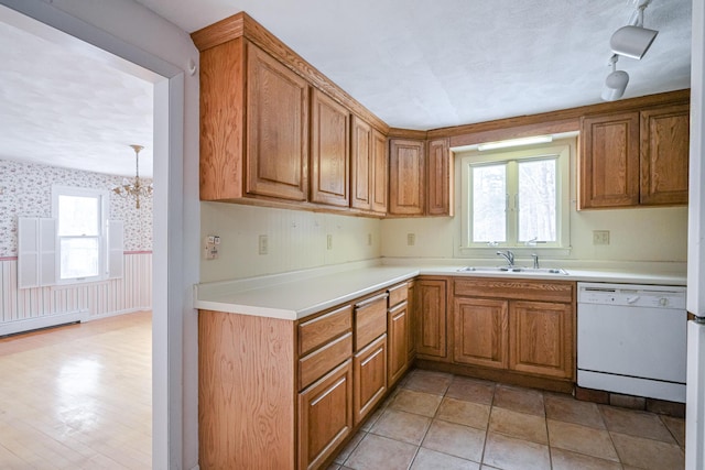 kitchen featuring sink, dishwasher, and a chandelier