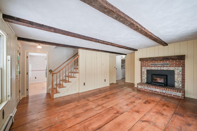 unfurnished living room featuring a baseboard heating unit, hardwood / wood-style floors, and beamed ceiling