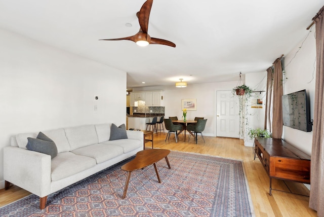 living room featuring ceiling fan and light wood-type flooring