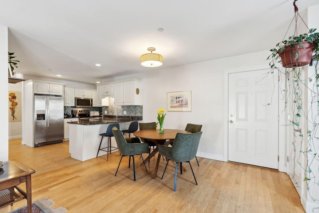 dining area with light hardwood / wood-style flooring and sink