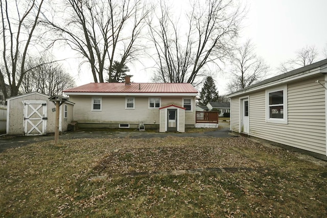 rear view of property with a wooden deck and a shed