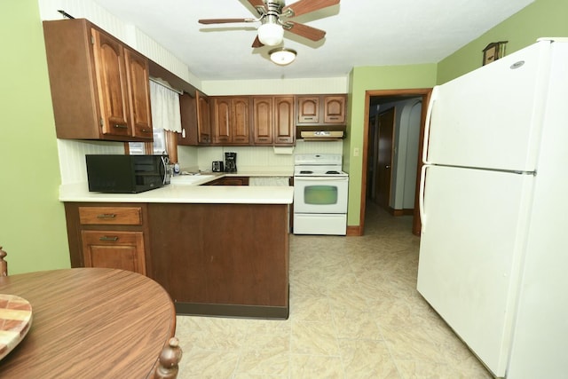 kitchen with white appliances, ceiling fan, and kitchen peninsula