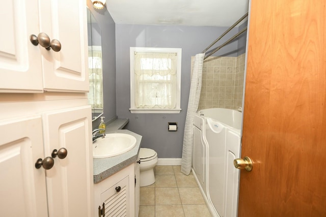 bathroom featuring toilet, a bath, tile patterned floors, and vanity