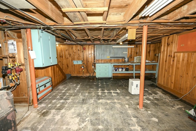 basement with wood walls and a workshop area