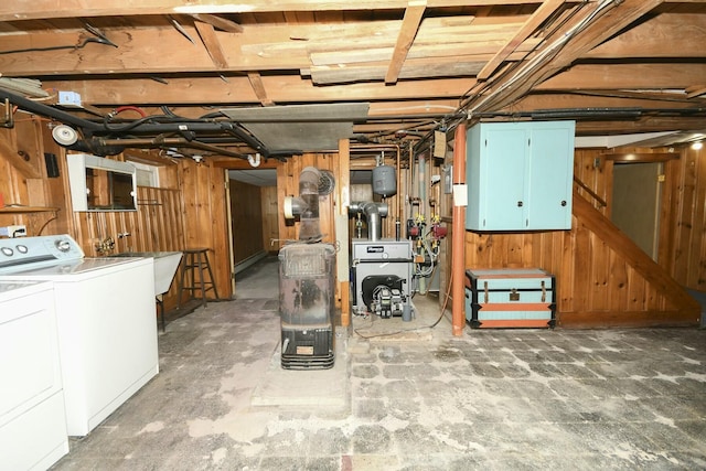 basement featuring washer and dryer, wooden walls, and sink