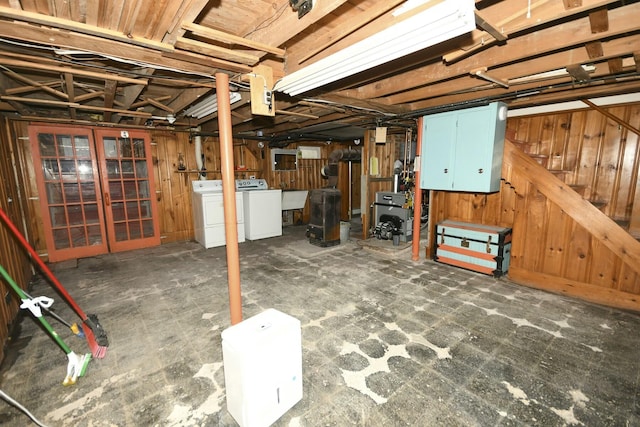 basement featuring sink, wooden walls, and separate washer and dryer