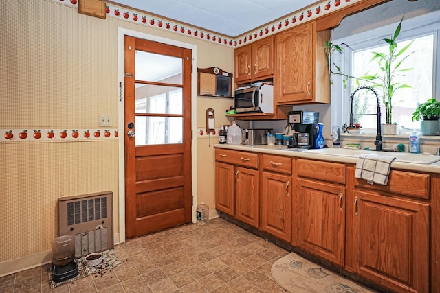 kitchen featuring heating unit and sink