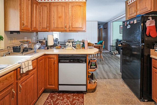 kitchen featuring black fridge and white dishwasher