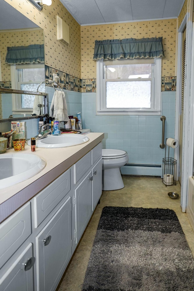 bathroom featuring vanity, a baseboard heating unit, and toilet