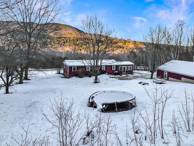 yard covered in snow featuring a mountain view