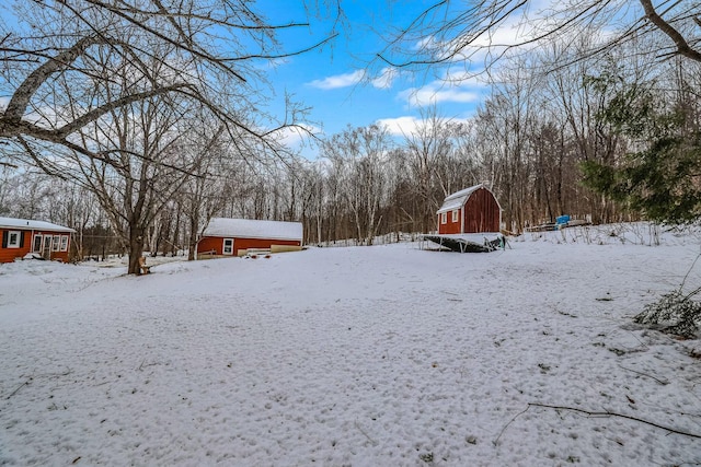 yard covered in snow featuring an outbuilding