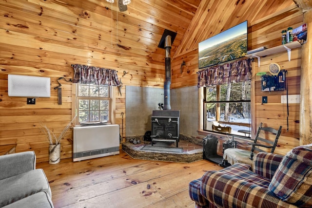 interior space with wooden ceiling, vaulted ceiling, a wood stove, hardwood / wood-style floors, and heating unit