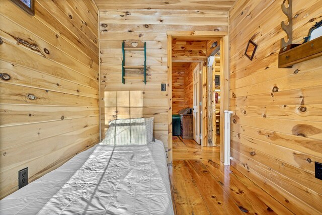 hallway featuring hardwood / wood-style floors and wooden walls