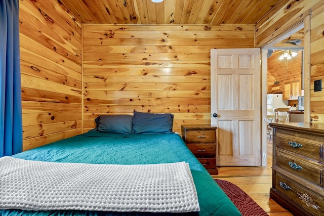 bedroom featuring wooden ceiling, wood walls, and light hardwood / wood-style flooring