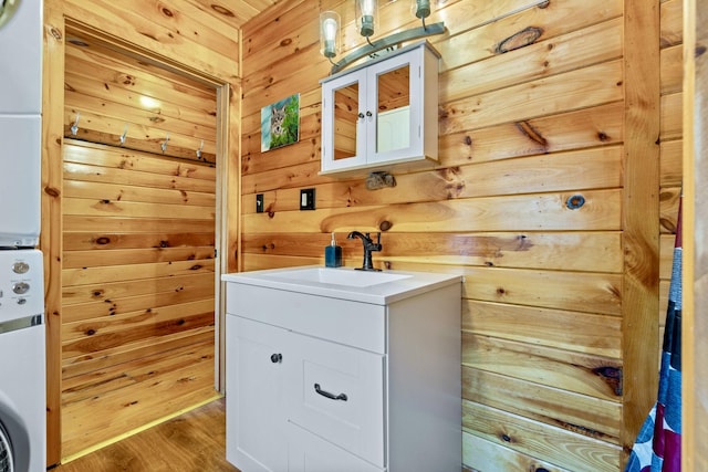 washroom featuring sink, wood walls, and hardwood / wood-style flooring