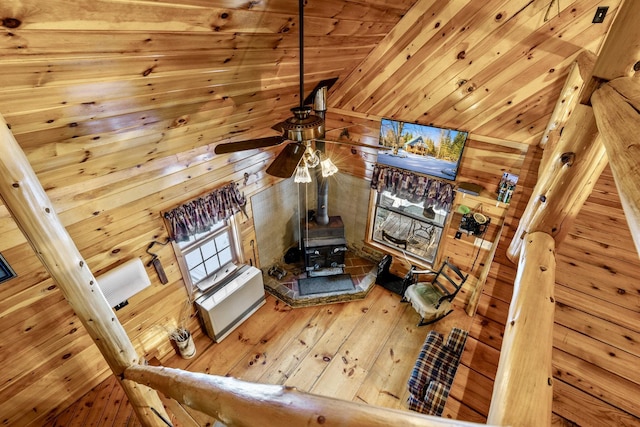 living room with wooden walls, wooden ceiling, and a wood stove