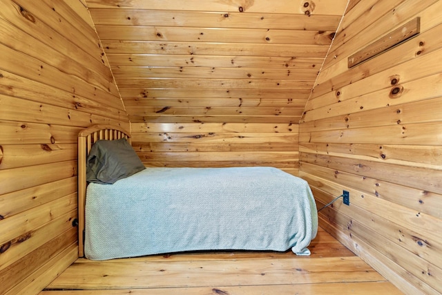 bedroom featuring wood ceiling and wood walls