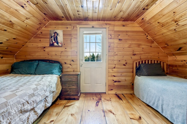 unfurnished bedroom featuring vaulted ceiling, wooden ceiling, wood walls, and wood-type flooring